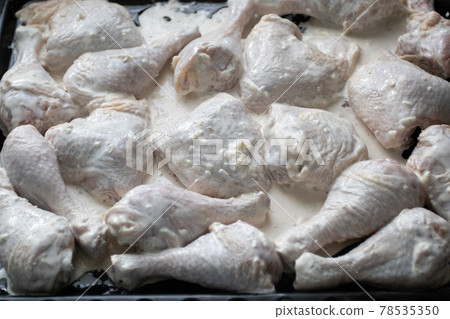 Raw, uncooked Chicken legs in garlic sauce on a baking sheet Raw, uncooked Chicken legs in garlic sauce on a baking sheet 78535350