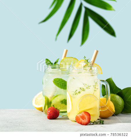 Lemonade and mojito on blue sky background close up Lemonade and mojito on blue sky background close up 78536322