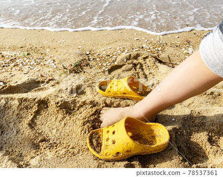 Children's feet and flip flops in the sand, playing on the beach Children's feet and flip flops in the sand, playing on the beach 78537361