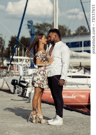 Happy couple embracing in port in summer Happy couple embracing in port in summer 78537655