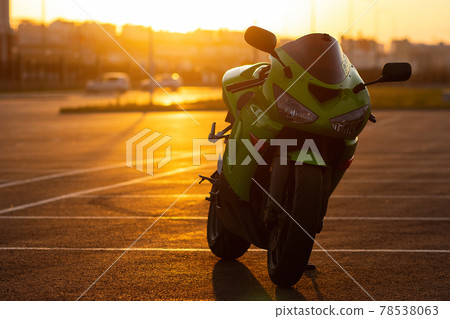 Cool man on motorcycle against sundown sky 78538063