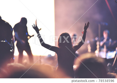 Rear view of a woman enjoying a concert 78538596