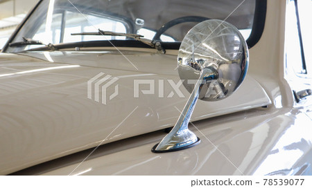 Car ZAZ-965 Zaporozhets Soviet subcompact car of the times of the USSR. Detail, the round rearview mirror located on the left side of the bonnet, close-up. An old little two-door car. Car ZAZ-965 Zaporozhets Soviet subcompact car of the times of the USSR. Detail, the round rearview mirror located on the left side of the bonnet, close-up. An old little two-door car. 78539077