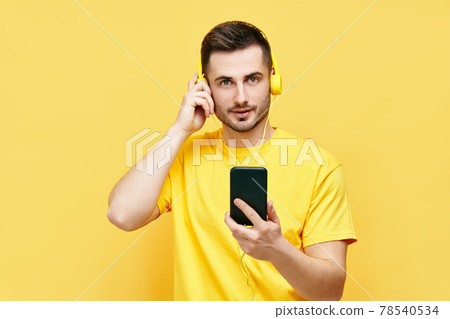 Handsome caucasian man listening to music from his phone and headphones 78540534
