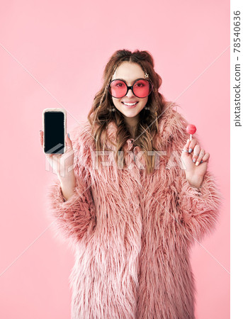 Smiling hipster woman holding blank screen mobile phone 78540636