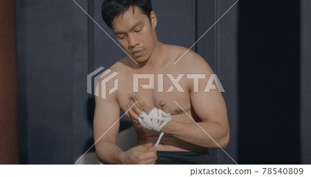 boxer man wraps protection knuckle or sports bandages on fist before training boxer man wraps protection knuckle or sports bandages on fist before training 78540809