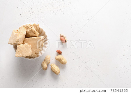 Sweet dessert peanuts halva on white background. 78541265