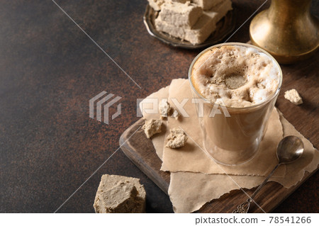 Tasty coffee latte with halva in glass cup. 78541266