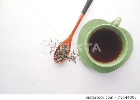 green tea and dry herbal leaf on spoon on white background  78544005