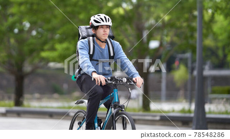 騎著自行車奔跑的送貨員 78548286