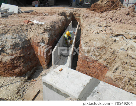 SEREMBAN, MALAYSIA -FEBRUARY 24, 2017: Underground utility and services pipe lay by workers at the construction site. SEREMBAN, MALAYSIA -FEBRUARY 24, 2017: Underground utility and services pipe lay by workers at the construction site. 78549204