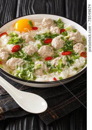 Thai Pork & Rice Soup Khao Tom Moo Sap closeup in the plate. Vertical 78549674