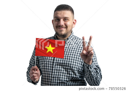 White guy holding a flag of Vietnam and shows two fingers isolated on a white background White guy holding a flag of Vietnam and shows two fingers isolated on a white background 78550326