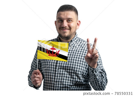White guy holding a flag of Brunei and shows two fingers isolated on a white background 78550331