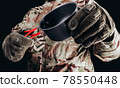 Soldier in gloves holding metal cup. 78550448