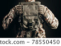 Soldier in gloves holding tactical leg bag. 78550450