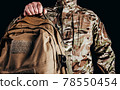 Soldier in gloves holding tactical backpack. 78550454