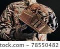 Soldier in gloves holding helmet with cover. 78550482