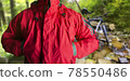 Man standing in travel hiking red jacket in woods. 78550486