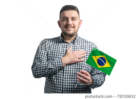 White guy holding a flag of Brazil and holds his hand on his heart isolated on a white background With love to Brazil 78550632