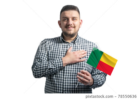White guy holding a flag of Benin and holds his hand on his heart isolated on a white background With love to Benin White guy holding a flag of Benin and holds his hand on his heart isolated on a white background With love to Benin 78550636