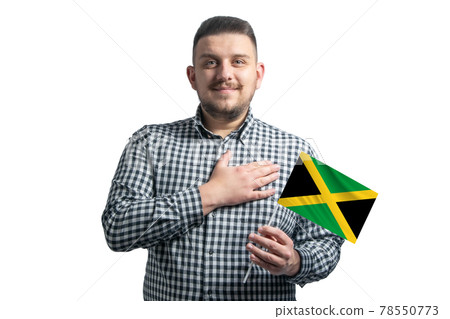 White guy holding a flag of Jamaica and holds his hand on his heart isolated on a white background With love to Jamaica White guy holding a flag of Jamaica and holds his hand on his heart isolated on a white background With love to Jamaica 78550773