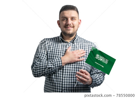 White guy holding a flag of Saudi Arabia and holds his hand on his heart isolated on a white background With love to Saudi Arabia White guy holding a flag of Saudi Arabia and holds his hand on his heart isolated on a white background With love to Saudi Arabia 78550800