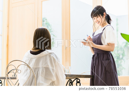 Young female clerk listening to an order at a cafe 78551036