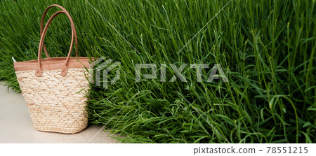 brown wicker bag with green grass in the background brown wicker bag with green grass in the background 78551215