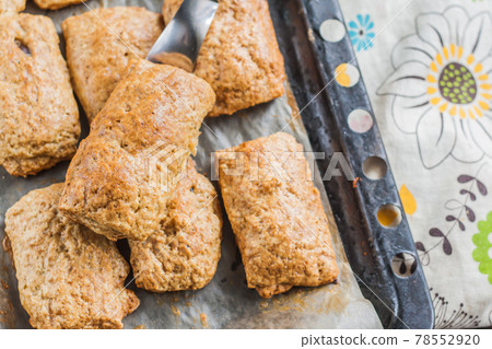 baked pies with chocolate filling on a baking sheet and colored napkin baked pies with chocolate filling on a baking sheet and colored napkin 78552920