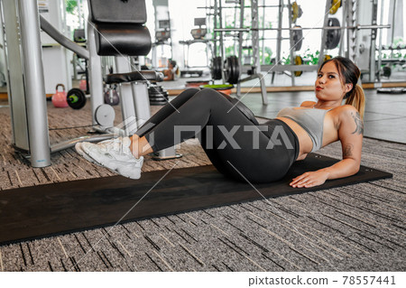 Asian sports woman in the gym, athletes training, workout lifting weight, plank and push up. tattoo Asian sports woman in the gym, athletes training, workout lifting weight, plank and push up. tattoo 78557441