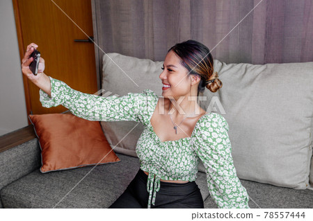 Pretty asian girl take a self portrait with her smart phone. Thai girl selfie. 78557444