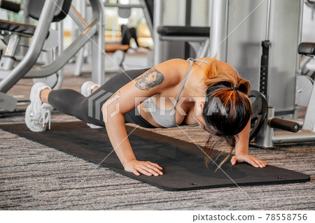 Asian sports woman in the gym, athletes training, workout lifting weight, plank and push up. tattoo Asian sports woman in the gym, athletes training, workout lifting weight, plank and push up. tattoo 78558756
