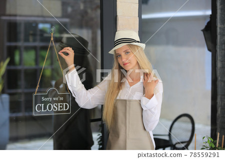 Beautiful blonde hair girl standing by cloesd shop sign plate at door with confidence in front of coffee shop. Beautiful blonde hair girl standing by cloesd shop sign plate at door with confidence in front of coffee shop. 78559291