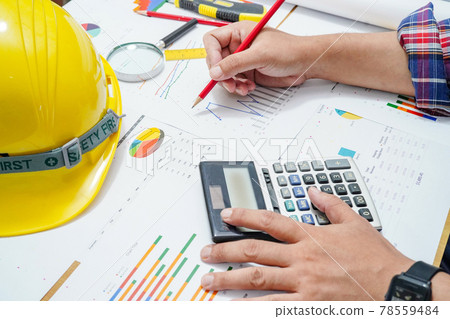 Architect or engineer working project accounting with graph with tools in office, Construction account concept. . Architect or engineer working project accounting with graph with tools in office, Construction account concept. . 78559484