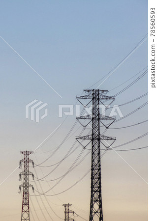 High-voltage power line towers and transmission lines alongside the blue sky 78560593
