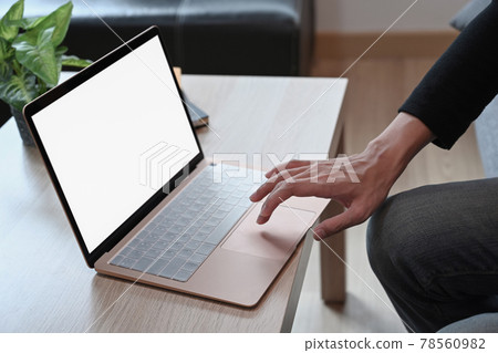 Cropped sho man using laptop on wooden table. Cropped sho man using laptop on wooden table. 78560982