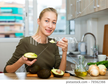 Happy housewife cooking with avocado at home kitchen 78562366