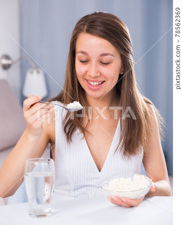 Young girl is enjoying tasty curd Young girl is enjoying tasty curd 78562369
