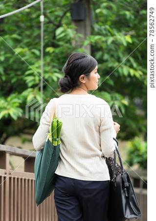 Business woman walking with an eco bag hanging from her shoulder on a suspension bridge 78562749