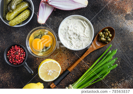 Tartar sauce in a bowl with organic ingredients from classic recipe top view on rustic dark metall surface Tartar sauce in a bowl with organic ingredients from classic recipe top view on rustic dark metall surface 78563837