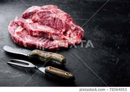 Raw marbled steak, Rib eye cut, on black stone background 78564053
