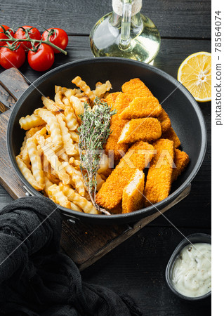 Fried fish finger stick or french fries fish with sauce, on frying iron pan, on black wooden table background 78564074