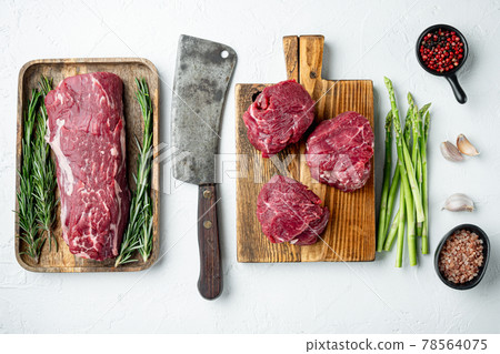 Fillet Mignon tenderloin raw meat veal and beef steaks, on wooden cutting board, on white stone surface, top view flat lay Fillet Mignon tenderloin raw meat veal and beef steaks, on wooden cutting board, on white stone surface, top view flat lay 78564075