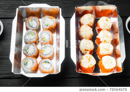 Set of sushi rolls in delivery food box, on black wooden table background Set of sushi rolls in delivery food box, on black wooden table background 78564078