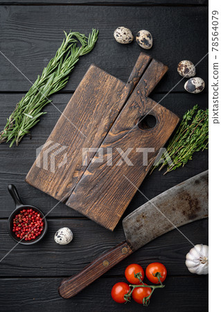 Empty cutting wooden board with butcher knife, top view, on black wooden background with copy space 78564079
