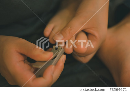 Mother cutting a child's toenails Mother cutting a child's toenails 78564671