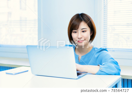 A lady who uses a laptop in the living room A lady who uses a laptop in the living room 78564727