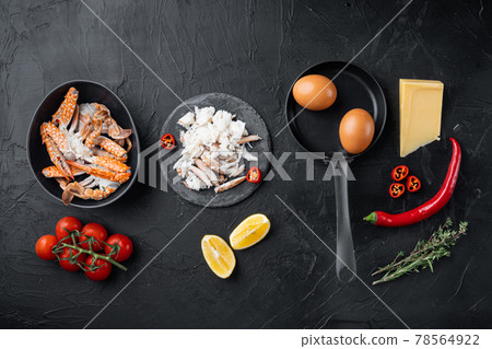 Spanish or Thai omelette ingredient, fresh red chilli, brown and white crabmeat, lemon, Cheddar cheese, eggs, on black background, top view flat lay 78564922