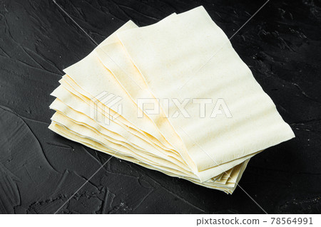 Lasagna dough sheets, on black stone background 78564991